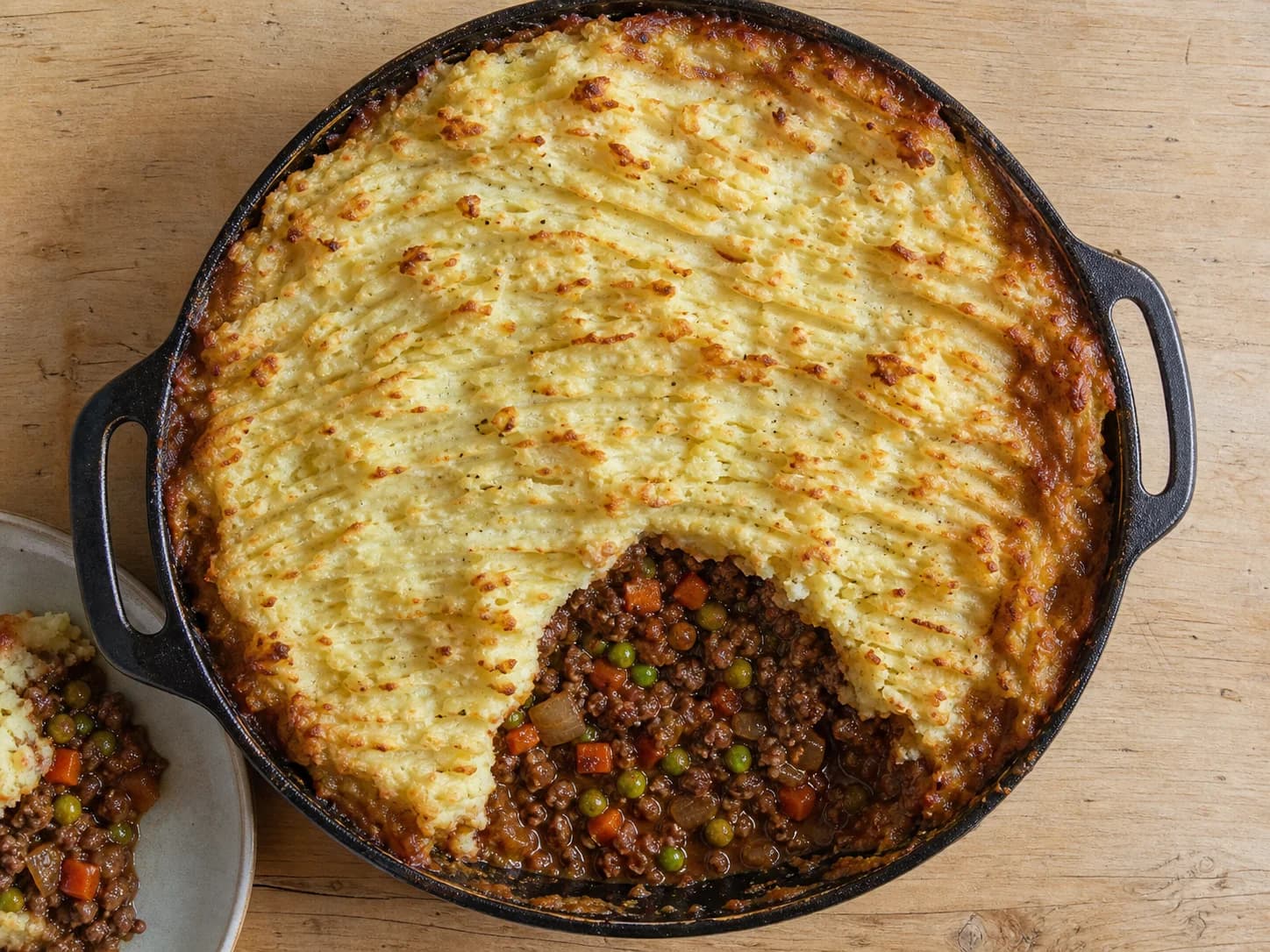 Overhead view of cottage pie with beef & vegetables, served as a family dinner.