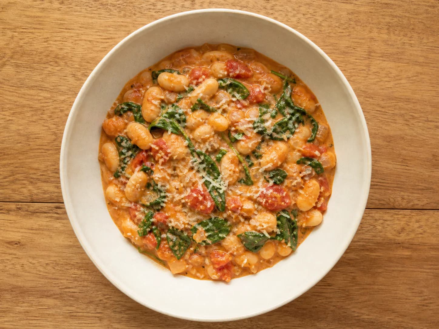 Cannellini beans and spinach in a creamy tomato sauce with a small amount of parmesan.