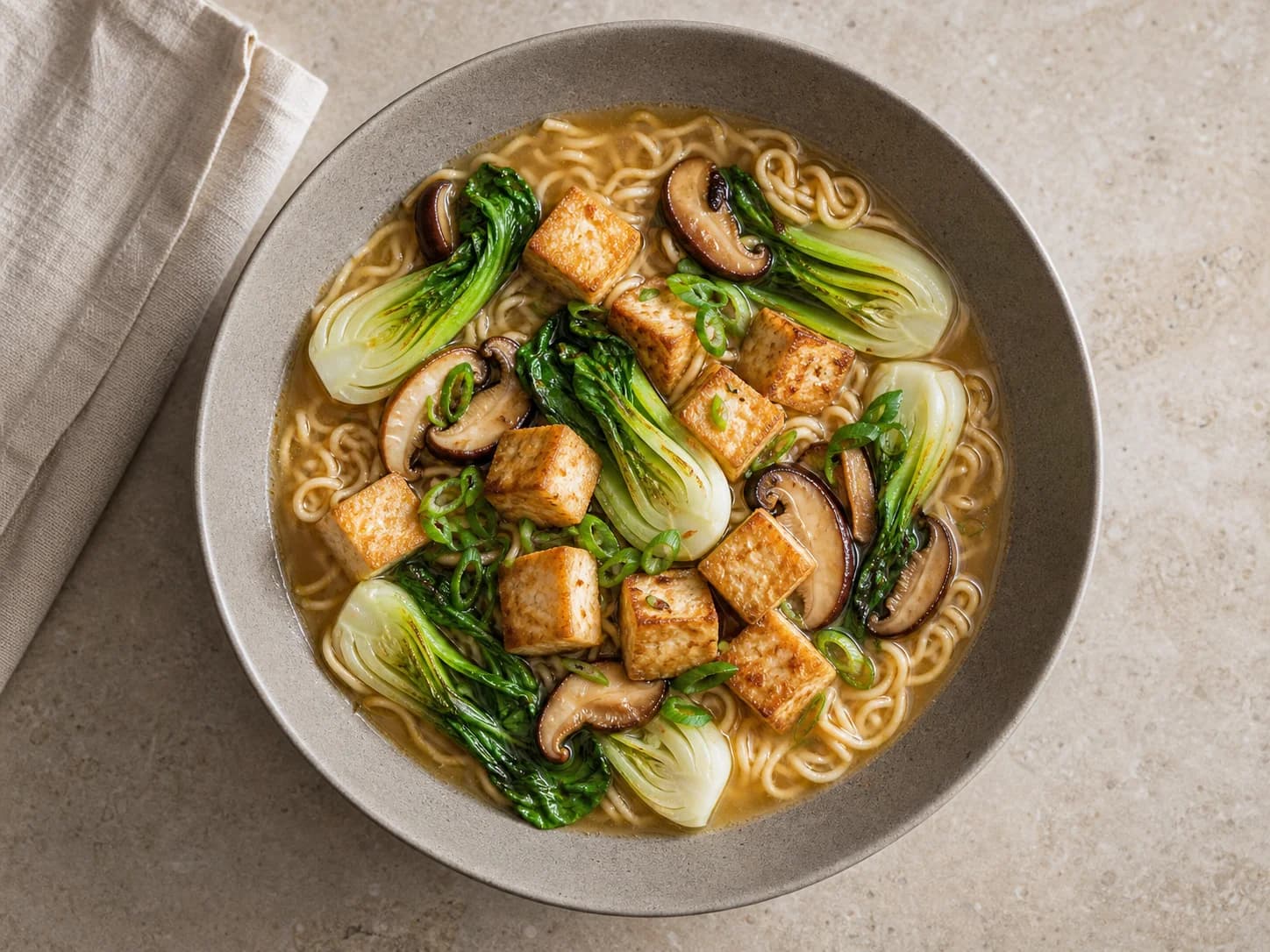 Overhead view of ginger-sesame tofu ramen bowls, served as a family dinner.