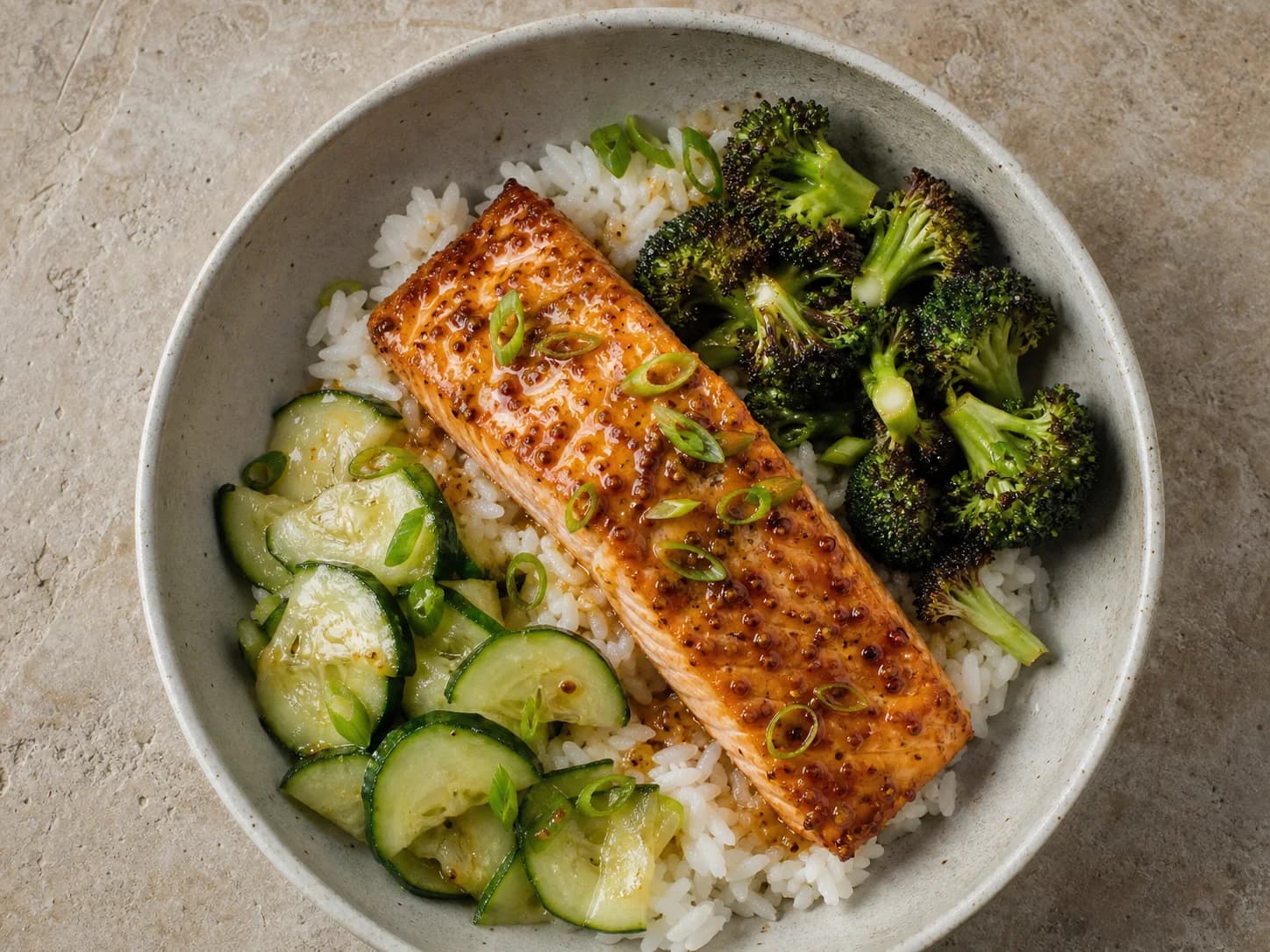 Overhead view of maple-mustard salmon rice bowls, served as a family dinner.