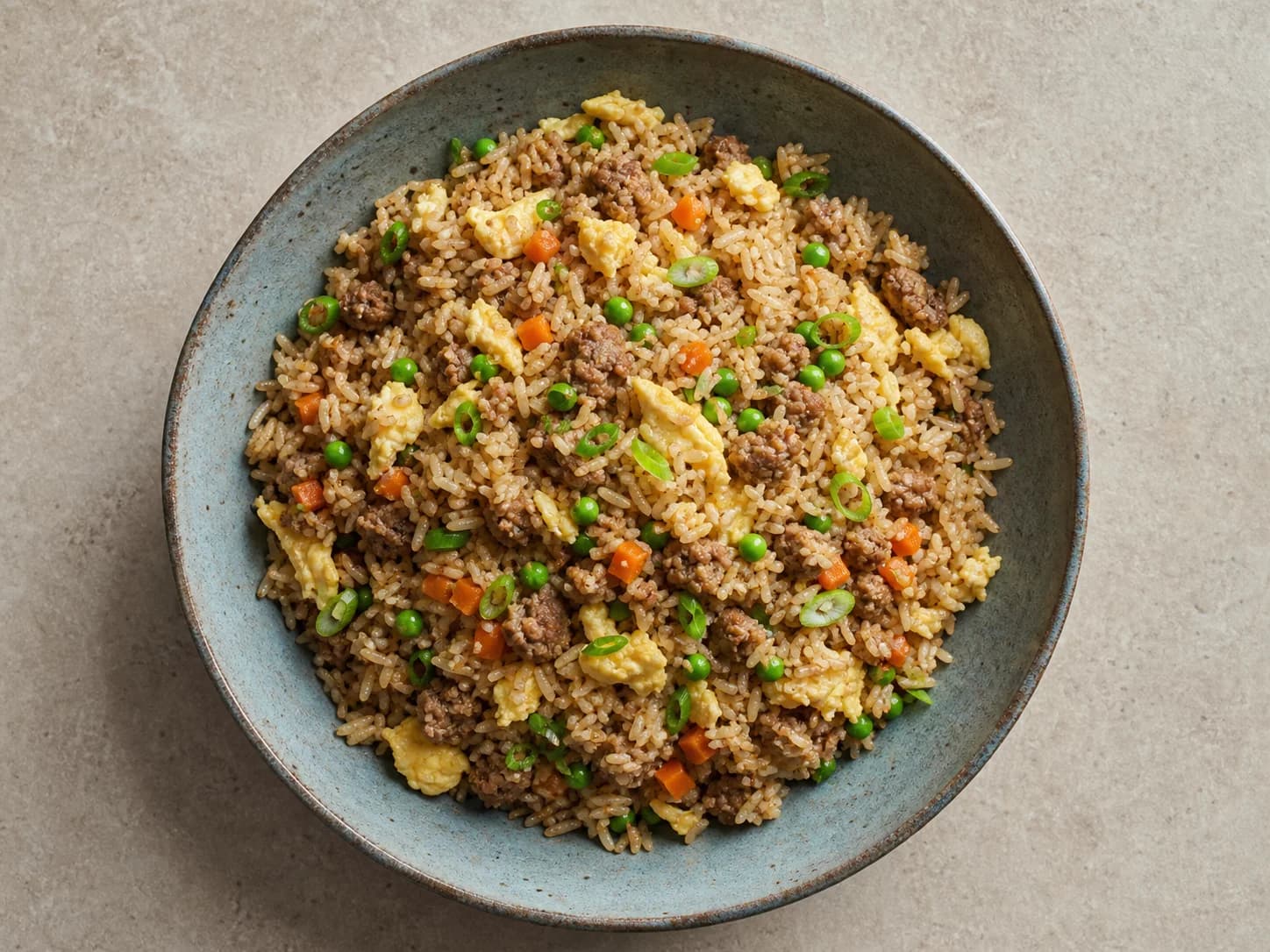 Overhead view of pork fried rice with peas, served as a family dinner.