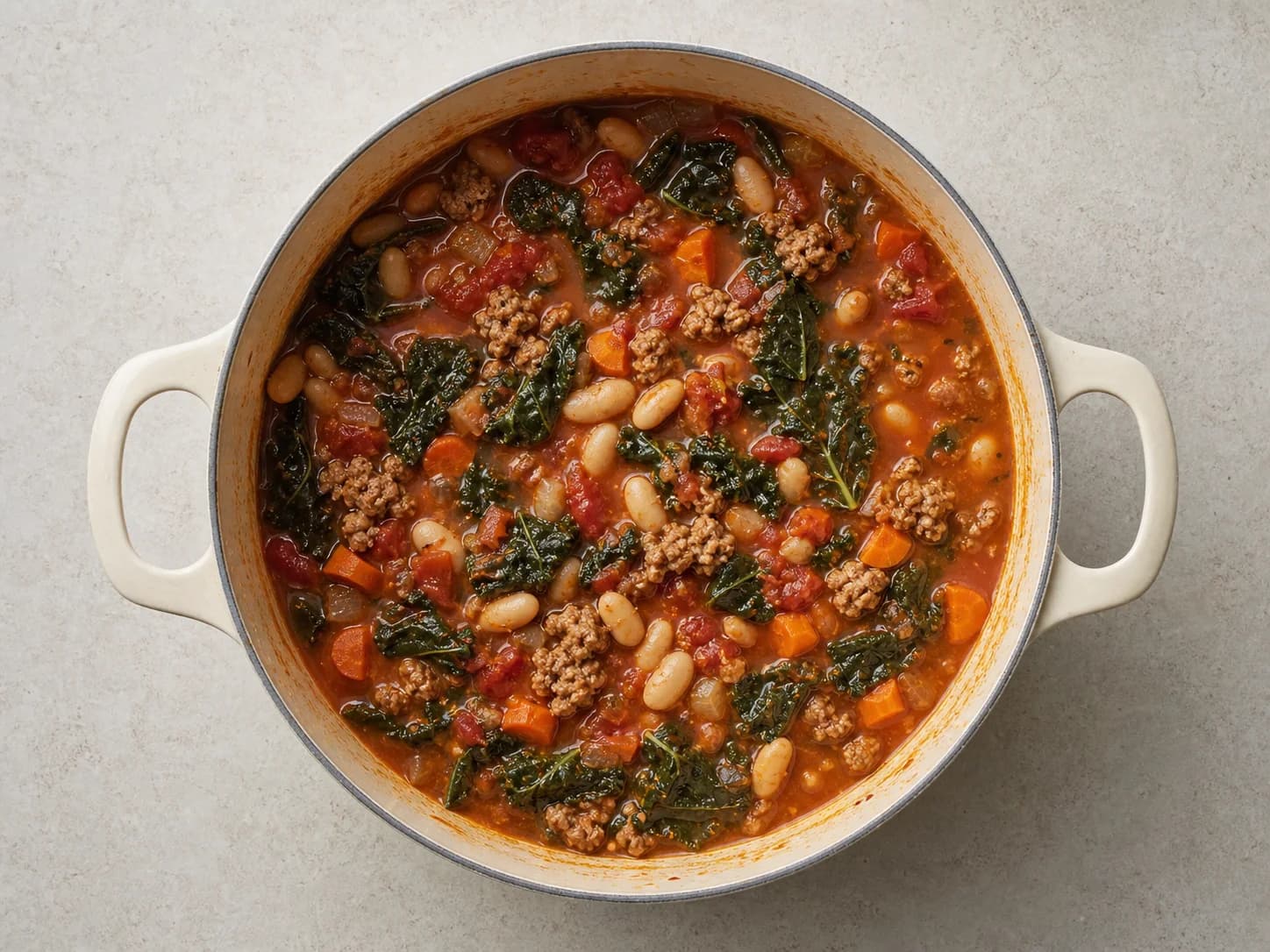 Overhead view of sausage, kale & white-bean soup, served as a family dinner.