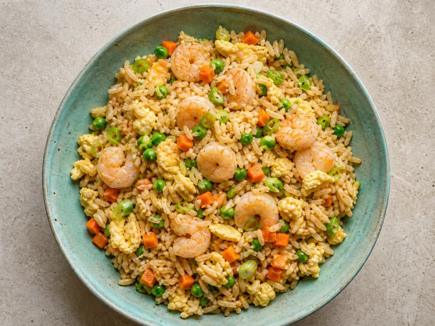 Overhead view of shrimp fried rice & vegetables, served as a family dinner.