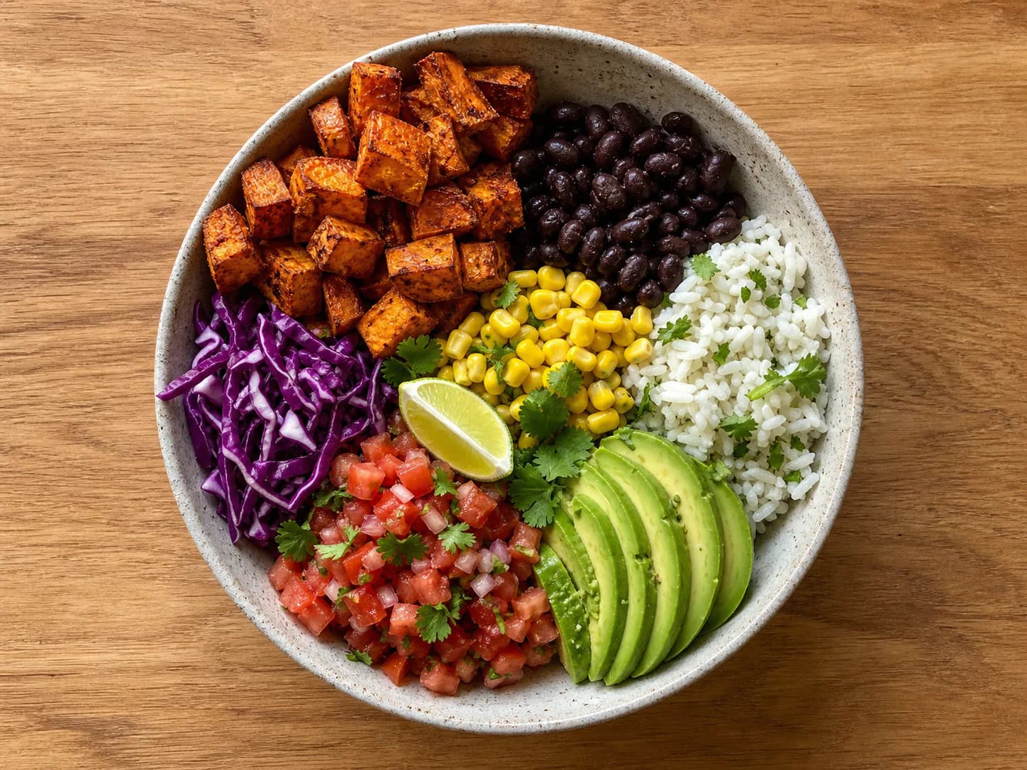 Taco bowl with roasted sweet potatoes, black beans, rice, corn, cabbage, pico and avocado.