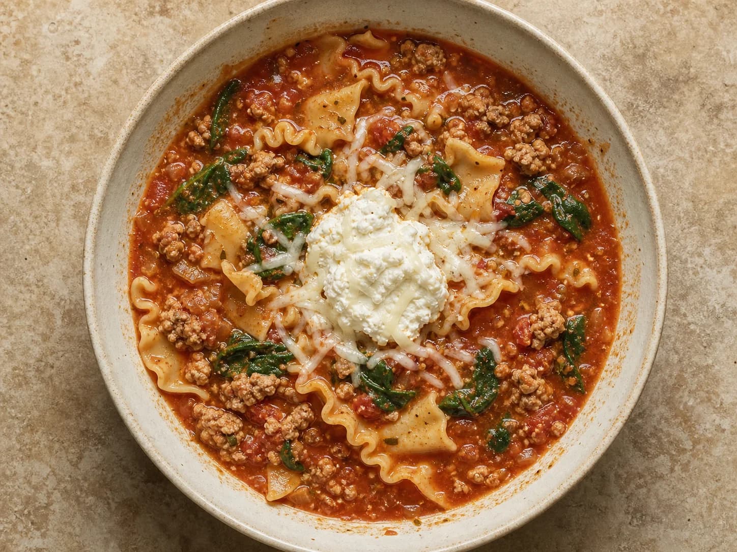 Overhead view of turkey lasagna soup, served as a family dinner.