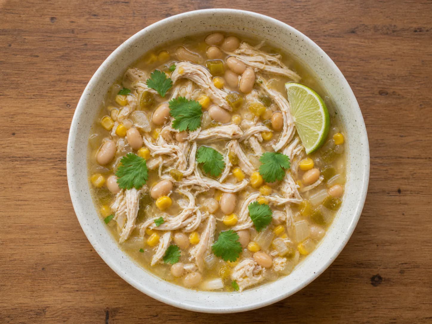 White chicken chili with shredded chicken, white beans, corn, mild green chiles, cilantro and lime.