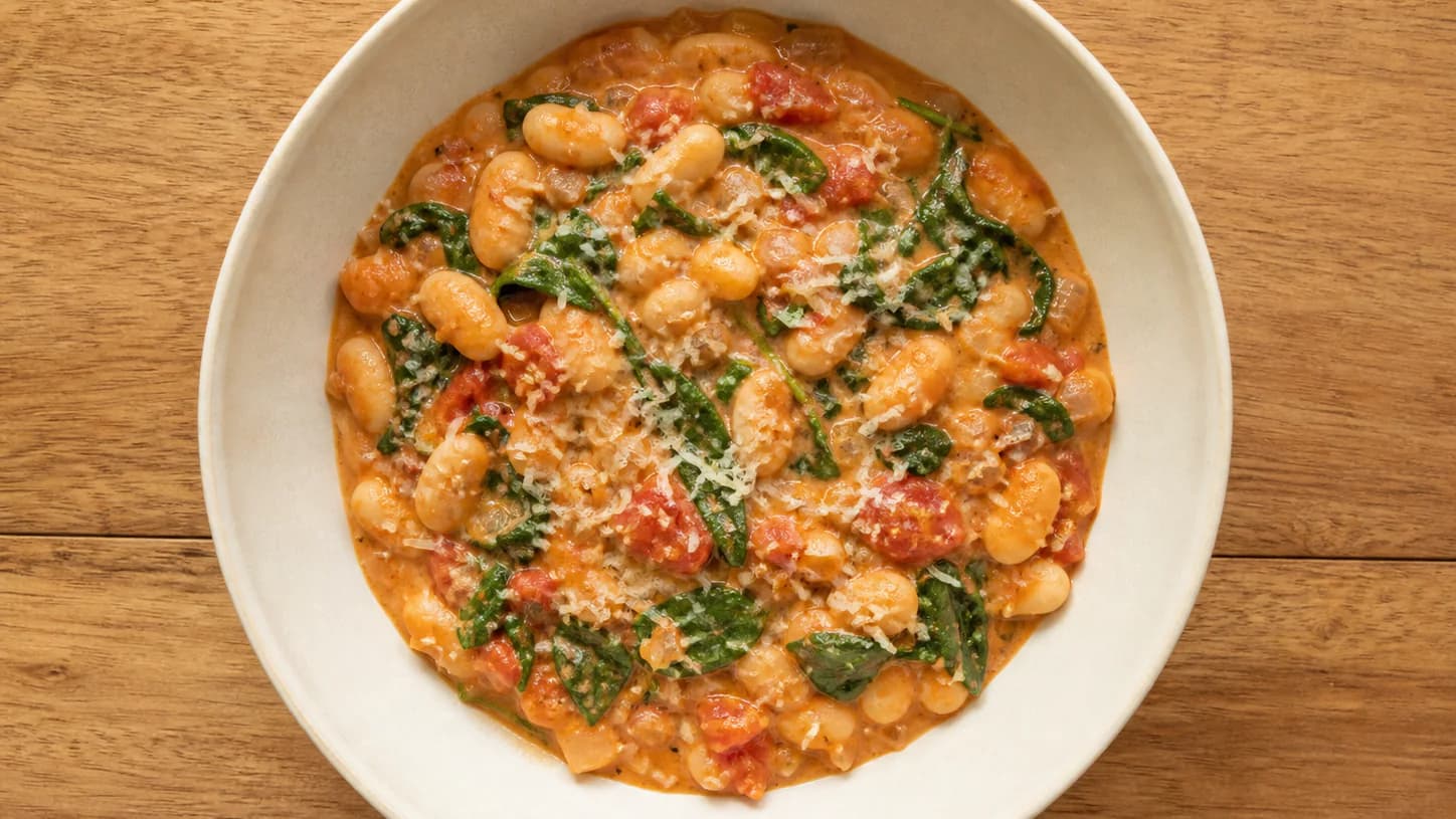 Cannellini beans and spinach in a creamy tomato sauce with a small amount of parmesan.