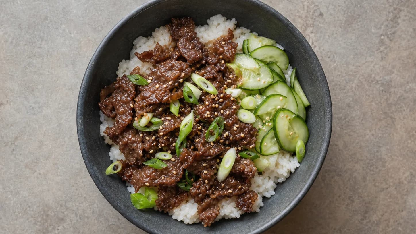 Overhead view of korean-inspired beef & cucumber rice bowls, served as a family dinner.