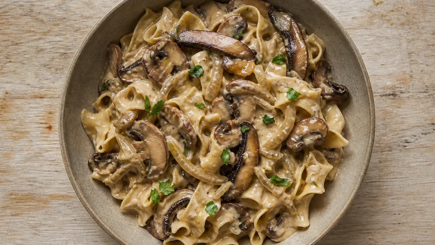 Overhead view of mushroom stroganoff & egg noodles, served as a family dinner.
