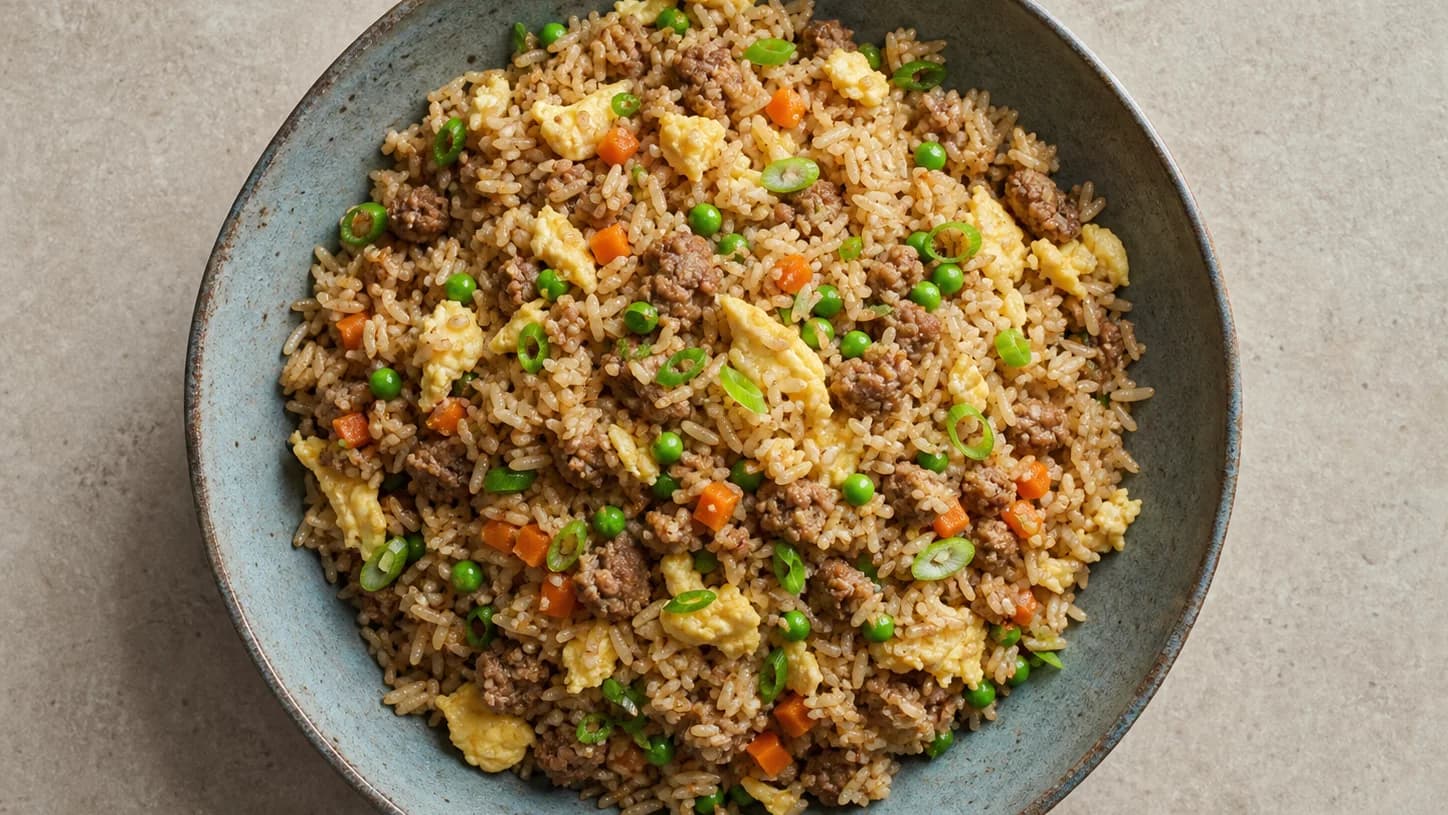Overhead view of pork fried rice with peas, served as a family dinner.