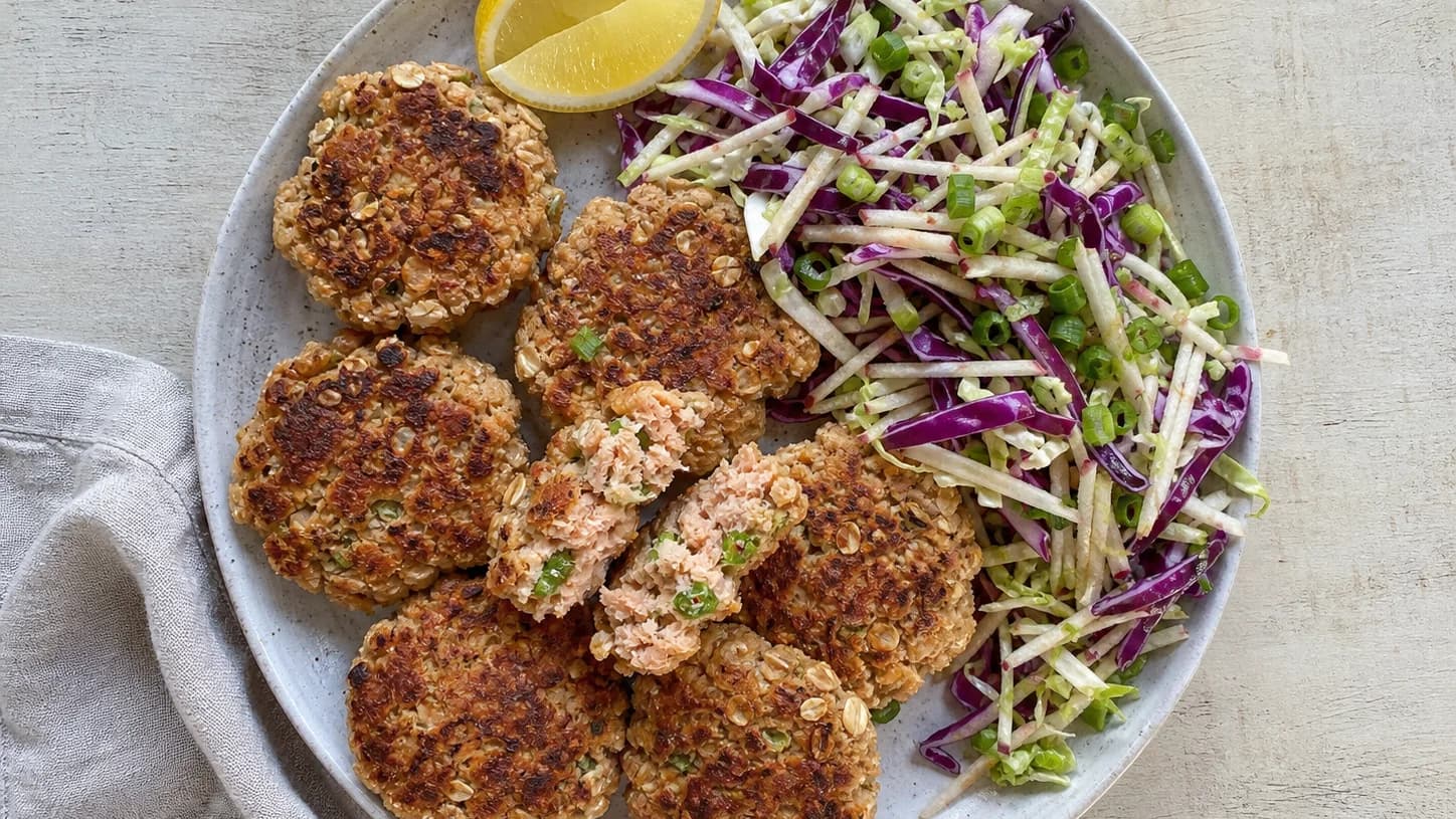 Overhead view of salmon cakes & crunchy slaw, served as a family dinner.
