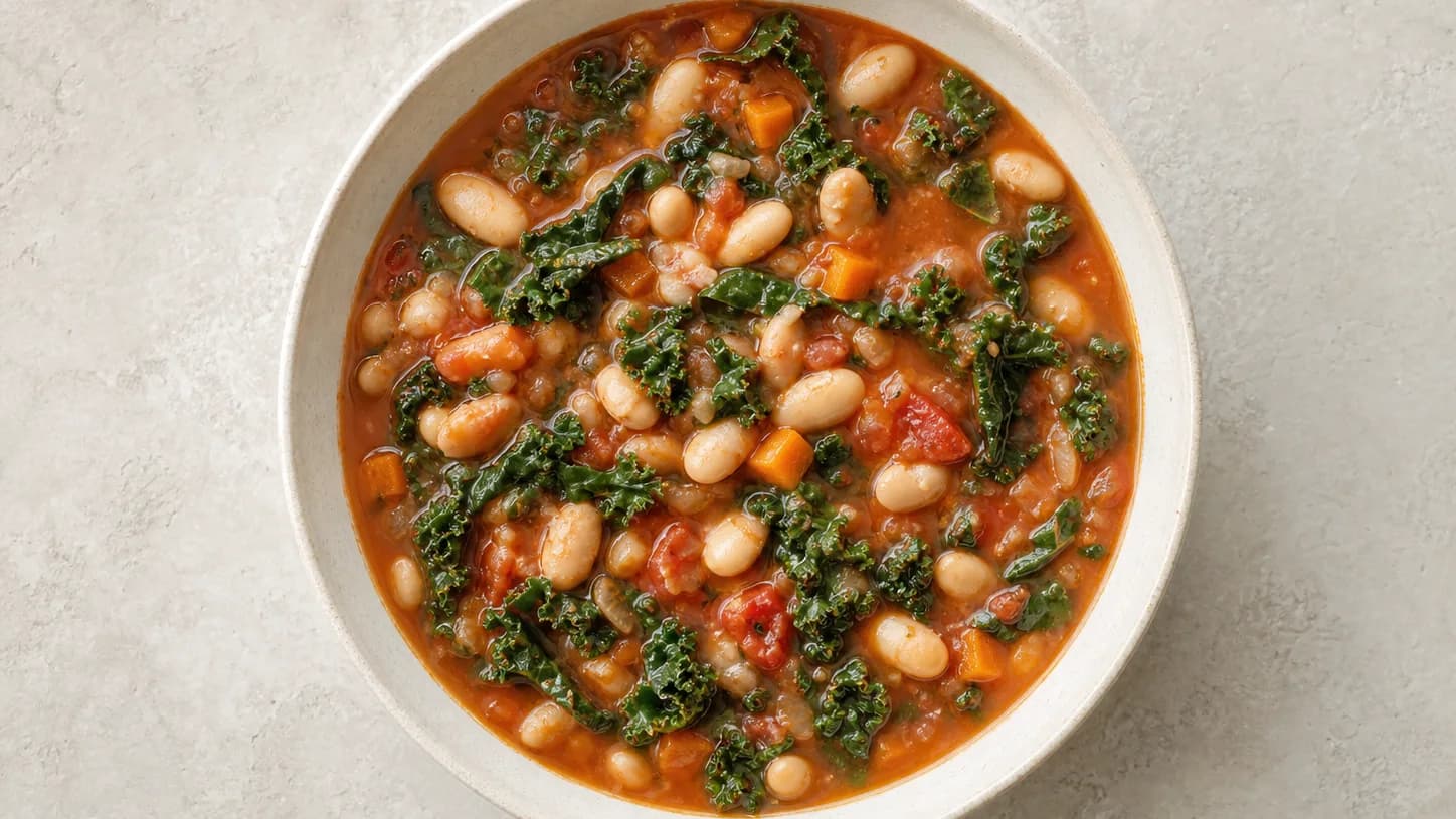 Overhead view of white-bean kale tomato soup, served as a family dinner.